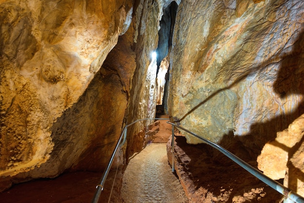 Ruta turística en una hermosa y antigua cueva oscura con muchas estalactitas. Grotte di Is Zuddas, Italia, Cerdeña