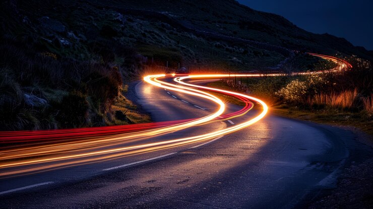 Rutas de luces de automóviles en la carretera nocturna con efecto de larga exposición