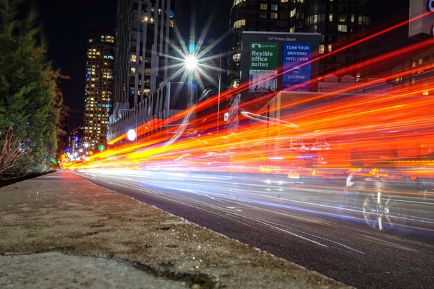 Foto rutas de luz en la calle de la ciudad por la noche