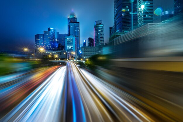 Foto rutas de luz en edificios iluminados de la ciudad por la noche