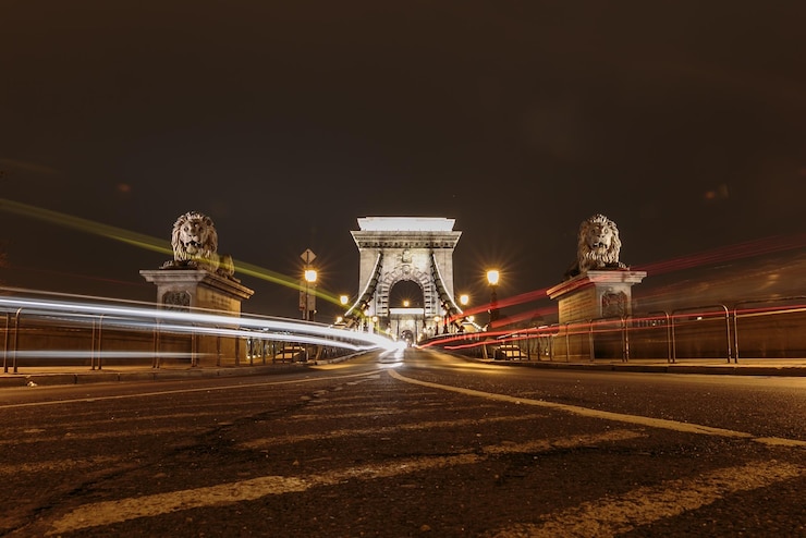 Foto rutas de luz en el puente de la cadena de szechenyi en la ciudad por la noche