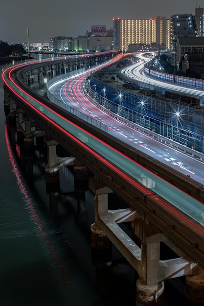 Foto rutas de luz en el puente sobre el río por la noche