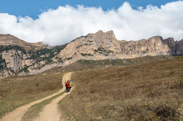 Rutas de senderismo y senderismo en la cordillera en el día soleado Turistas mochileros familiares senderismo Digoria Montañas del Cáucaso