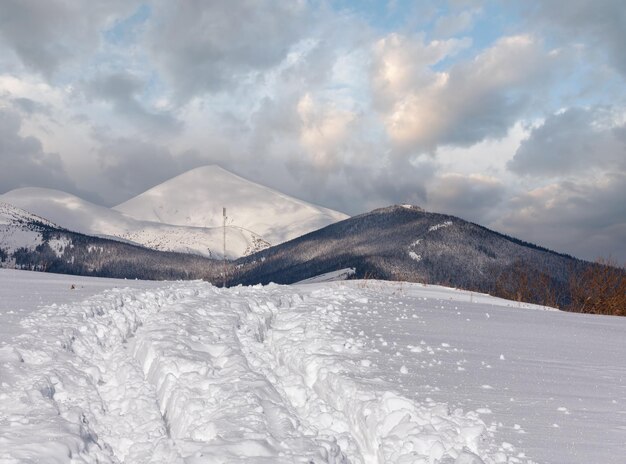 Foto rutas de trineo y huellas en la cima de la montaña de invierno