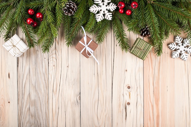 Árvore de abeto com decorações de Natal e caixas de presente em fundo de madeira