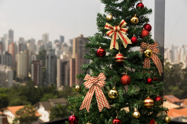 Árvore de Natal à luz do dia, com paisagem da cidade