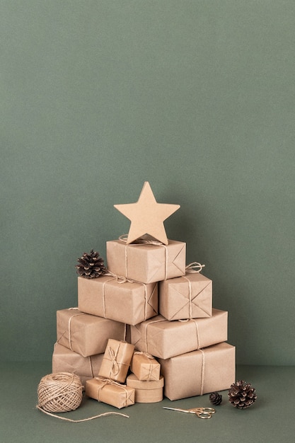 Árvore de Natal abstrata. Caixas em papel ofício, barbante, tesoura, cones em fundo verde, closeup. Feriado de Natal ou ano novo de conceito. Vista frontal Copie o espaço.