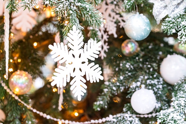 Árvore de Natal ao ar livre com flocos de neve brancos e decoração