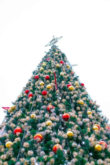Árvore de Natal artificial com guirlandas e bolas na rua. Vista de baixo para cima. Comemoração de Ano Novo e Natal.