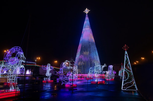 Árvore de Natal, árvore de ano novo lá fora à noite, sob a neve.