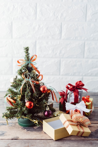 Árvore de Natal com caixa de presente na mesa de madeira