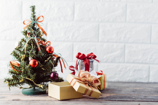 Árvore de Natal com caixa de presente na mesa de madeira