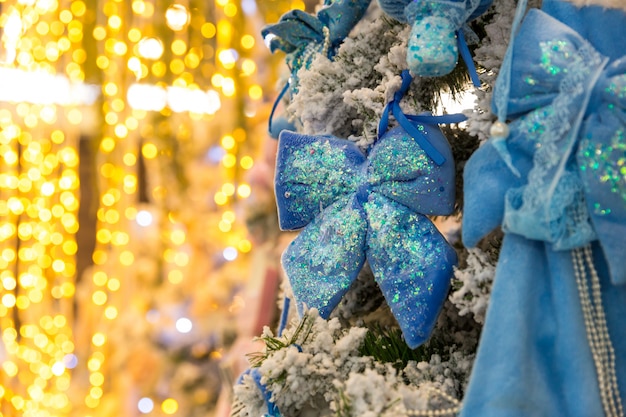 Árvore de Natal com decoração e luzes azuis, closeup de festão. Decoração de Natal, ano novo. Celebração do feriado de inverno