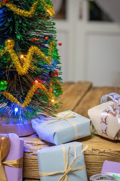 Árvore de Natal com decoração e presentes em um fundo branco de madeira