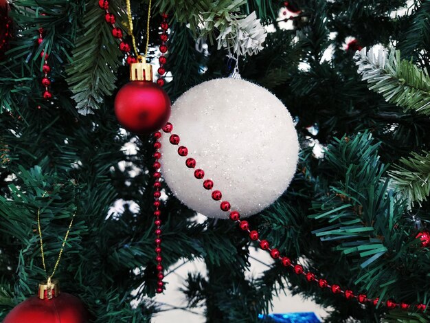 Árvore de Natal com enfeites Bolas de Natal e brinquedos Enfeites pendurados vermelhos e brancos Bolas grandes e pequenas contas vermelhas