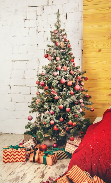 Árvore de Natal com enfeites e presentes. Foco seletivo.