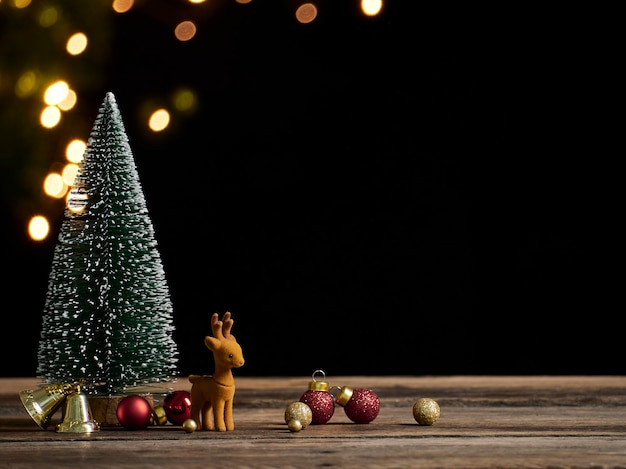 Árvore de Natal com renas na mesa de madeira vintage rústica. Efeito bokeh, espaço para texto