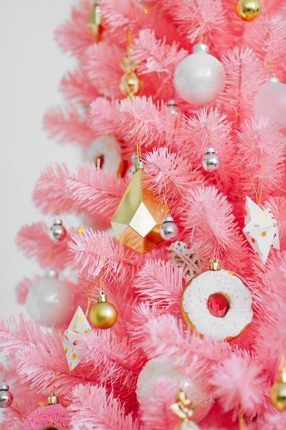 Árvore de Natal cor-de-rosa e decorações de Natal brancas e douradas. Fundo de Natal. Feliz ano novo e conceito de Natal de Natal.