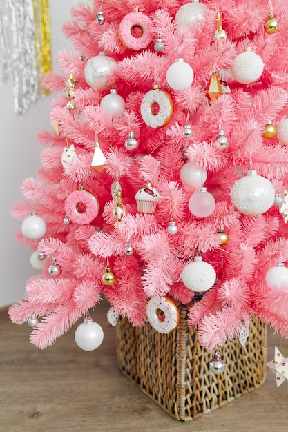 Árvore de Natal cor-de-rosa e decorações de Natal brancas e douradas. Fundo de Natal. Feliz ano novo e conceito de Natal de Natal.