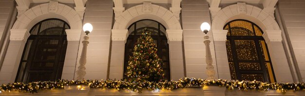 Árvore de Natal de banner decorada com luzes iluminando e bolas de bugiganga