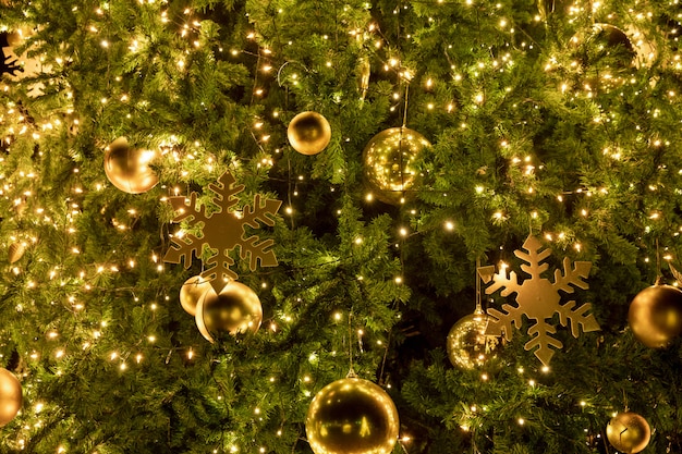 Árvore de Natal de close-up com decoração, bola de luz e ouro à noite no feriado de Natal e ano novo.