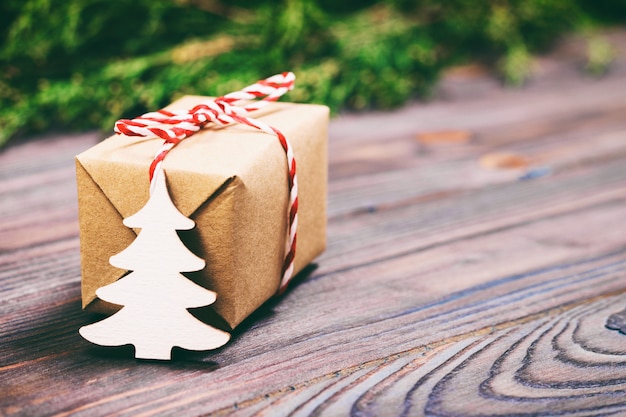 Árvore de Natal de madeira branca decorativa pequena e presente com presente de fita vermelha de papel kraft.