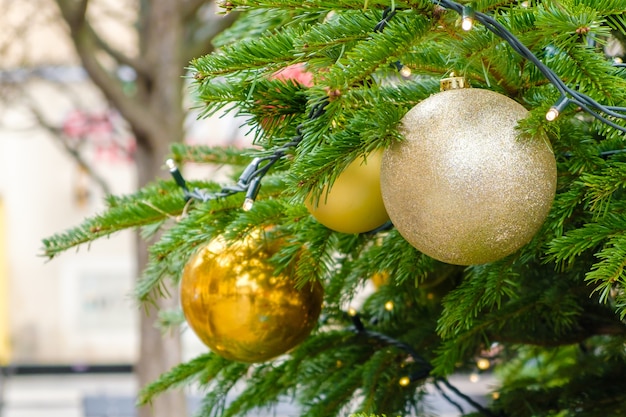 Árvore de natal decorada com bolas de brinquedo vermelhas e douradas na rua