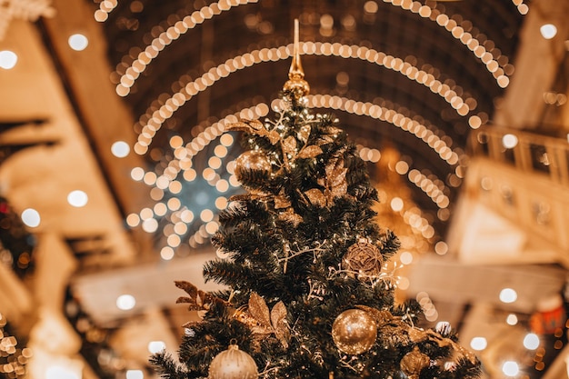 Árvore de Natal decorada com bolas de Natal. Detalhes de fadas. Luzes douradas de bokeh. Milagre festivo.