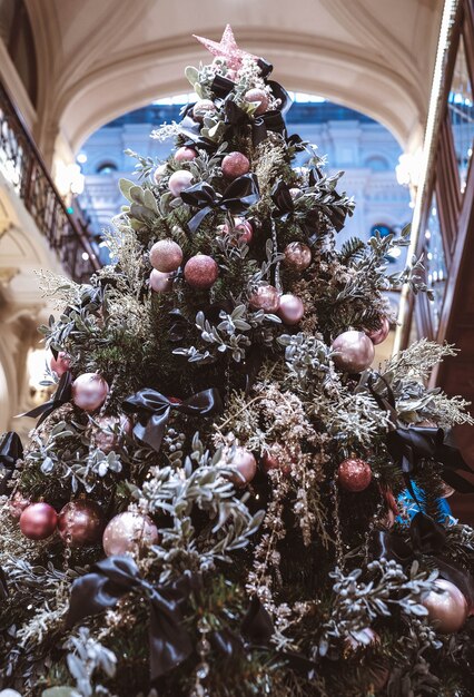 Árvore de Natal decorada com bolas rosa e laços de seda preta em um interior festivo. Atmosfera de feliz ano novo. Detalhes mágicos de natal