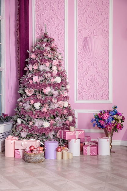 Árvore de Natal decorada com brinquedos rosa com presentes no interior do quarto