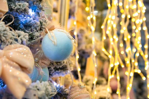 Árvore de Natal decorada com luzes e bolas azuis, closeup de festão. Decoração de Natal, ano novo. Celebração do feriado de inverno