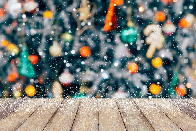 Árvore de Natal decorada de forma abstrata desfocar fundo de neve com mesa de madeira