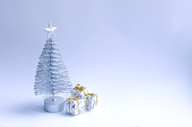Árvore de Natal decorativa e caixas de presente em fundo de neve fofa.