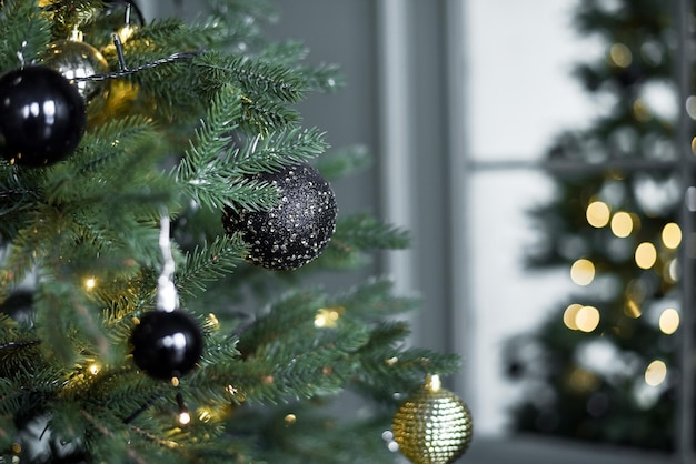 Árvore de Natal dourada escura decorada com bolas e guirlandas no interior da casa