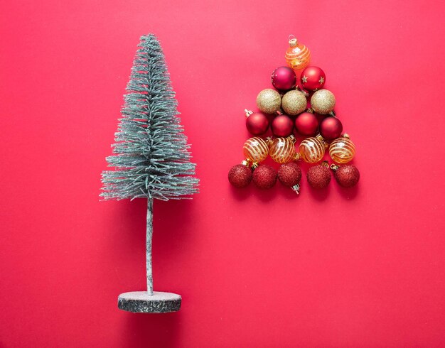 Árvore de Natal e bolas de decoração em fundo de cor vermelha Xmas bugigangas vermelhas e douradas