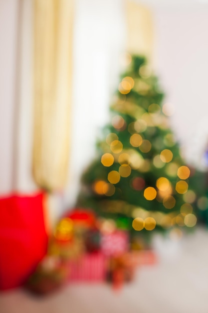 Árvore de Natal e presentes no quarto. Fundo desfocado de luzes desfocadas para design, conceito de férias