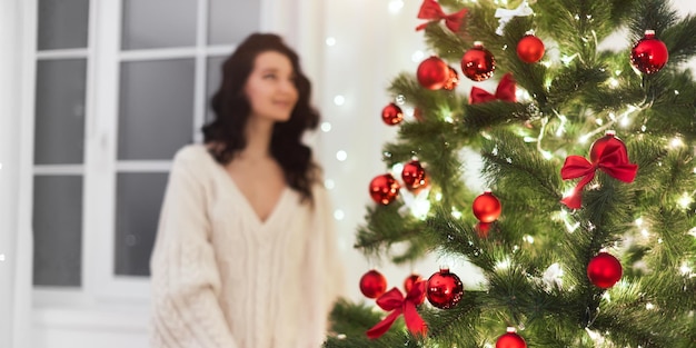 Árvore de Natal em casa e mulher desfocada dentro de casa