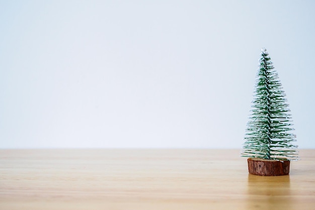 Árvore de Natal em mesa de madeira com fundo de parede branca