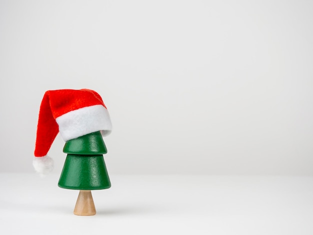 Árvore de Natal em um chapéu de Papai Noel em um fundo claro Natal e Ano Novo