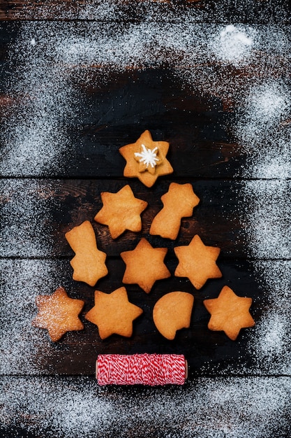 Árvore de Natal feita de biscoitos de gengibre em uma superfície de madeira velha.