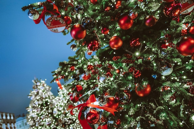 Árvore de Natal festiva decorada com brinquedos de Natal, fitas e bolas vermelhas. Férias de inverno