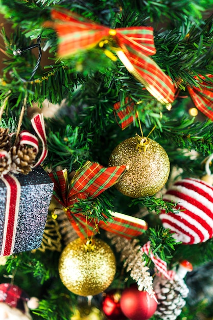 Árvore de Natal montada com enfeites. Bolas vermelhas, prata e ouro, caixas de presente, luzes, Papai Noel e outros. Foco seletivo.