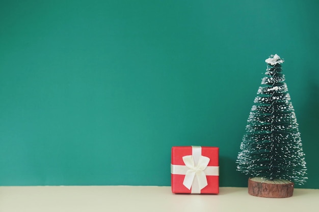 Árvore de Natal na mesa de madeira sobre fundo verde com espaço de cópia.