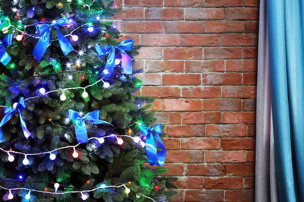 Árvore de Natal no fundo da parede de tijolos