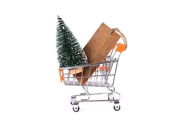 Árvore de Natal pequena e etiqueta de preço de papel no modelo de carrinho de compras com fundo branco