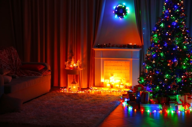 Árvore de Natal perto da lareira e outras decorações na sala