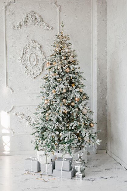 Árvore de Natal prateada com presentes debaixo dela em um interior clássico