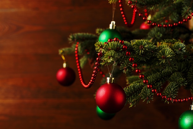 Árvore de Natal, vestido de bolas, fica em uma mesa de madeira. copyspace.