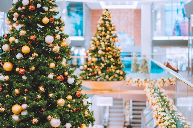 Árvores de Natal com decoração vermelha e dourada no shopping