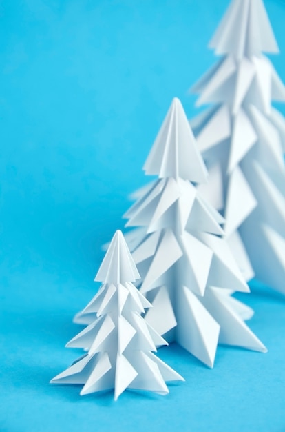 Árvores de Natal de origami de papel branco em azul